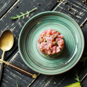 Fresh salmon tartare with avocado on elegant plate, perfect for food presentations.