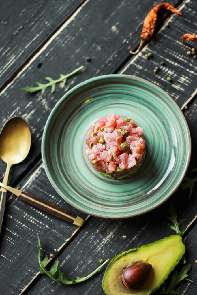 Fresh salmon tartare with avocado on elegant plate, perfect for food presentations.